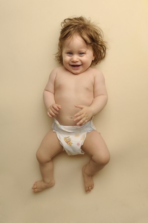 Little baby in diaper on beige backgroundの写真素材