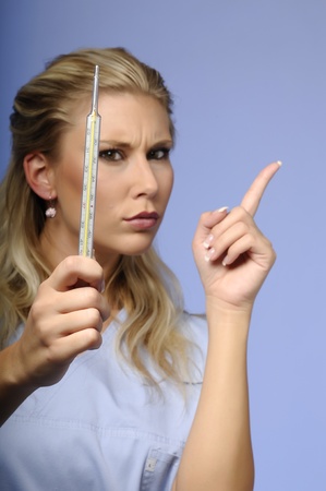 Portrait of blond girl warning with a thermometerの写真素材