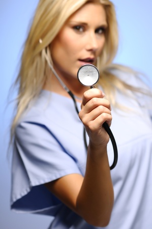 Sexy blond nurse showing stethoscope の写真素材