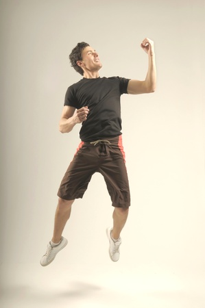 Attractive jumping man in a sport outfit and sport shoesの写真素材