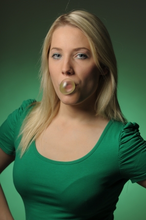 Young woman making a bubble from chewing gumの写真素材