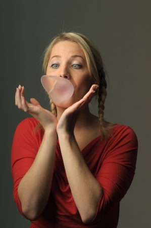 Young woman making bubble from chewing gumの写真素材