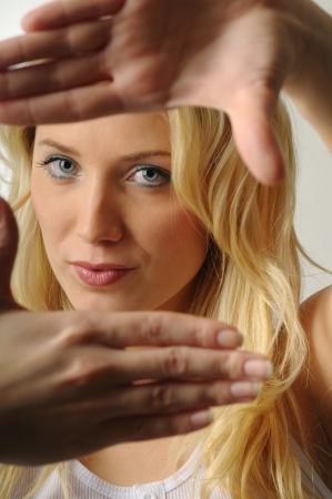 Young woman pretending picture frame with her handsの写真素材
