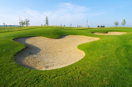 golf course with bunker and nice green and blue skyの写真素材