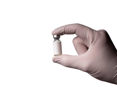 A glass vial in which a liquid with a vaccine is in the doctor's hand with a glove. Glass bottle with liquid isolated on white backgroundの写真素材