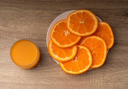 Glass glass with orange juice and orange stand on a wooden gray table on a dark background Fresh juice conceptの写真素材
