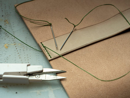 Making a leather case for batteries by a tanner, on a green self-healing mat, leather craftsmanship...