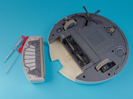 The robot vacuum cleaner is disassembled, the vacuum cleaner is being cleaned and disassembled, the concept of repairing a robot vacuum cleaner, and advertising prevention and replacement of filtersの写真素材
