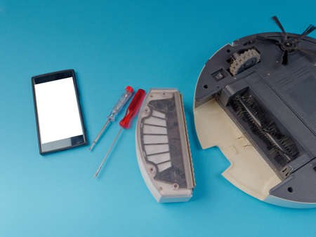 The robot vacuum cleaner is disassembled, the vacuum cleaner is being cleaned and disassembled, the concept of repairing a robot vacuum cleaner, and advertising prevention and replacement of filtersの写真素材