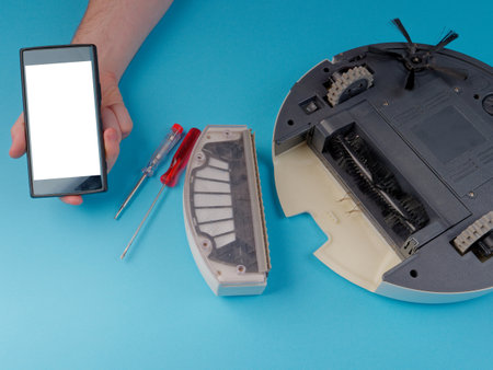 The robot vacuum cleaner is disassembled, the vacuum cleaner is being cleaned and disassembled, the concept of repairing a robot vacuum cleaner, and advertising prevention and replacement of filtersの写真素材
