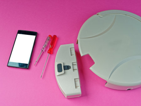 The robot vacuum cleaner is disassembled, the vacuum cleaner is being cleaned and disassembled, the concept of repairing a robot vacuum cleaner, and advertising prevention and replacement of filtersの写真素材