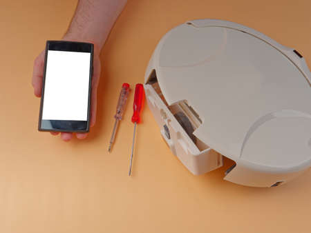 The robot vacuum cleaner is disassembled, the vacuum cleaner is being cleaned and disassembled, the concept of repairing a robot vacuum cleaner, and advertising prevention and replacement of filtersの写真素材