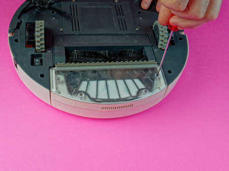 The robot vacuum cleaner is disassembled, the vacuum cleaner is being cleaned and disassembled, the concept of repairing a robot vacuum cleaner, and advertising prevention and replacement of filtersの写真素材