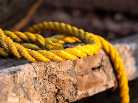 Destroyed light concrete slabs, tied with a thick yellow rope, cable. construction and replacement concept.の写真素材