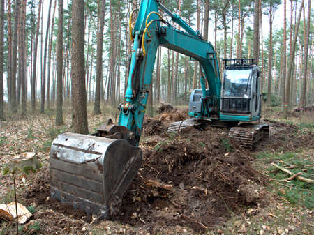 Tractor digging the ground with a bucket, bucket close-up, tree cutting concept, Deforestation.の写真素材