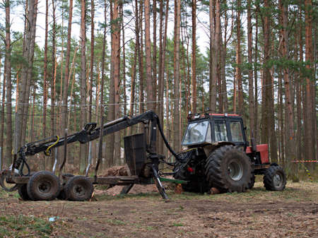 Tractor that collects felled trees stands sideways, tree cutting concept, Deforestation.の写真素材