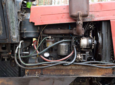 Tractor that collects felled trees stands sideways, Motor close up, Deforestation.の写真素材