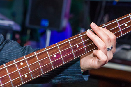 man playing bass guitar in black and yellow.
