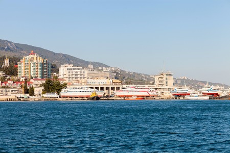 Spring sun day panorama of Black Sea pier and port harbor in Yalta.のeditorial素材