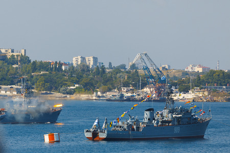 Crimea - 26 July 2015: parade in honor of the Day Russian Navy in Sevastopol. MTSCH Kovrovets 913 performs volley shots in the water area of the cityのeditorial素材