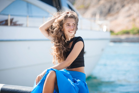 Beautiful young happy woman on sea boats backgroundの写真素材