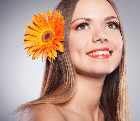 Beautiful young woman with a flower in her hair Gerberaの写真素材