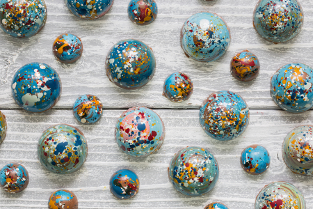 Chocolate handmade candy in the form of a planet. On a white wooden backgroundの写真素材