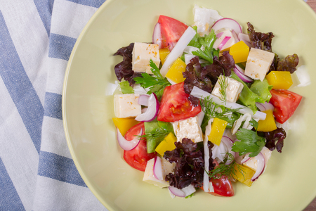 Appetizing fresh Greek salad with feta cheese, fresh vegetables and black olives.の写真素材