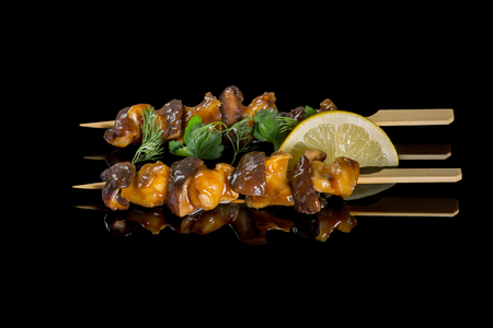 Shiitake cooking on a grill. On a black background with reflectionの写真素材