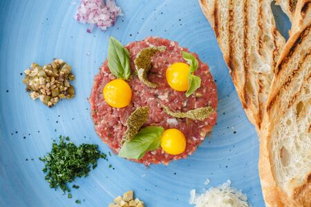 Tartar on a blue plate with croutons.の写真素材