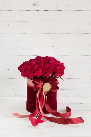 Red velvet box with roses. Decorated with red ribbon.の写真素材