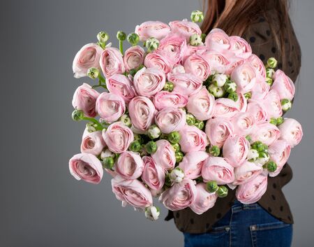 Beautiful large bouquet of buttercups in the hands of a florist.の写真素材