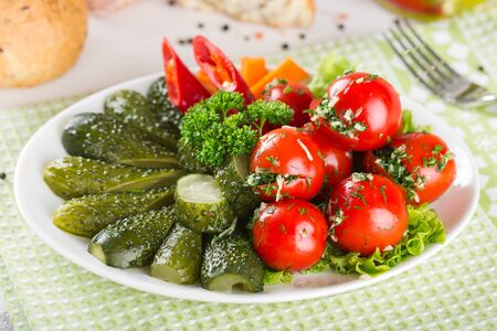 Assorted pickles on a plate. Tomato, cucumber, pepper, garlic.の写真素材