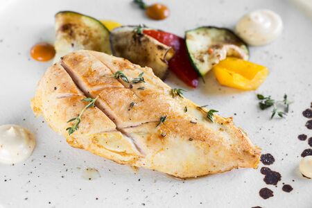 Grilled chicken breast served with baked vegetables. Close-up.の写真素材