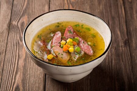 Pea soup with smoked meats in a plate on a wooden background.の写真素材