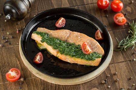 Grilled red fish steak. Served in a pan with cherry tomatoes and pesto.の写真素材
