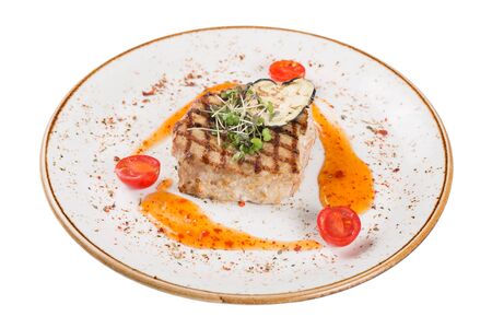 Pork steak served on a plate with sauce and microgreens. Isolated on a white background.の写真素材