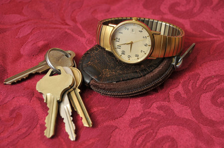 keys on a key ring, wrist watch, and a worn coin pouch