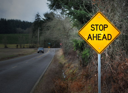 STOP AHEAD road street sign in rural country landscape.