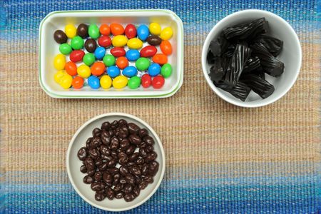 A selection of chocolate colorful beans, black Australian licorice, or chocolate covered raisins.の写真素材