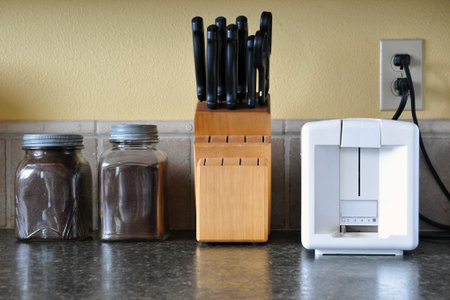 Kitchen counter top with coffee jars, knife set, and toasterの写真素材