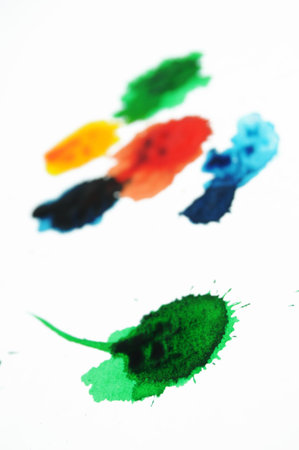 Abstract closeup photograph of colorful ink and paint splotches, splatters, dabs, dribbles, and...