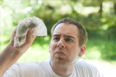 A young man cleaning the window with a paper towel and window cleaner.の写真素材