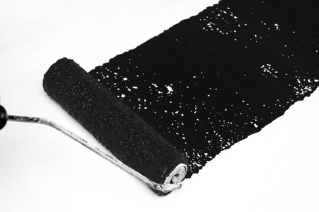 Wet Black paint being painting on a white surface with a roller.の写真素材