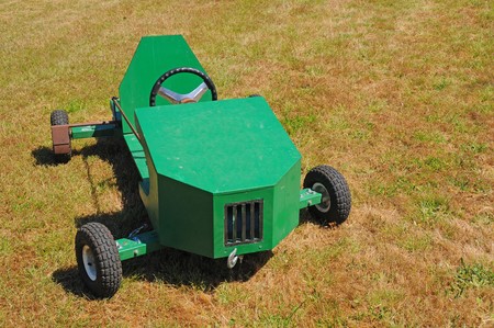 A green soapbox racing car displayed on the grass.の写真素材