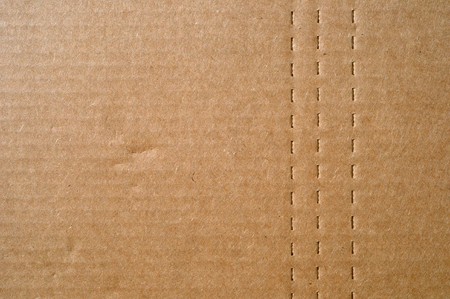 Flat brown cardboard  background texture with perforated lines that will help the box fold.の写真素材