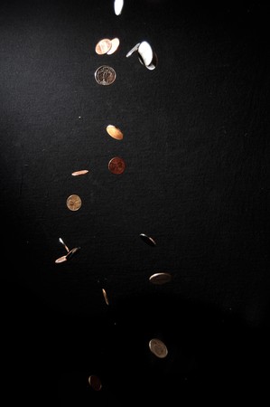 Coins falling into the darknessの写真素材