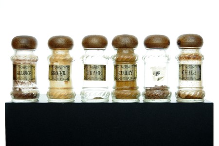 A variety of different spices on a black counter top.の写真素材