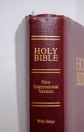 New Internation Version with Helps of the Holy Bible with a red leather cover isolated on a white backgroundの写真素材