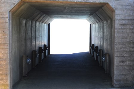 A dark square walkway tunnel with blank white copyspace on the other side.の写真素材